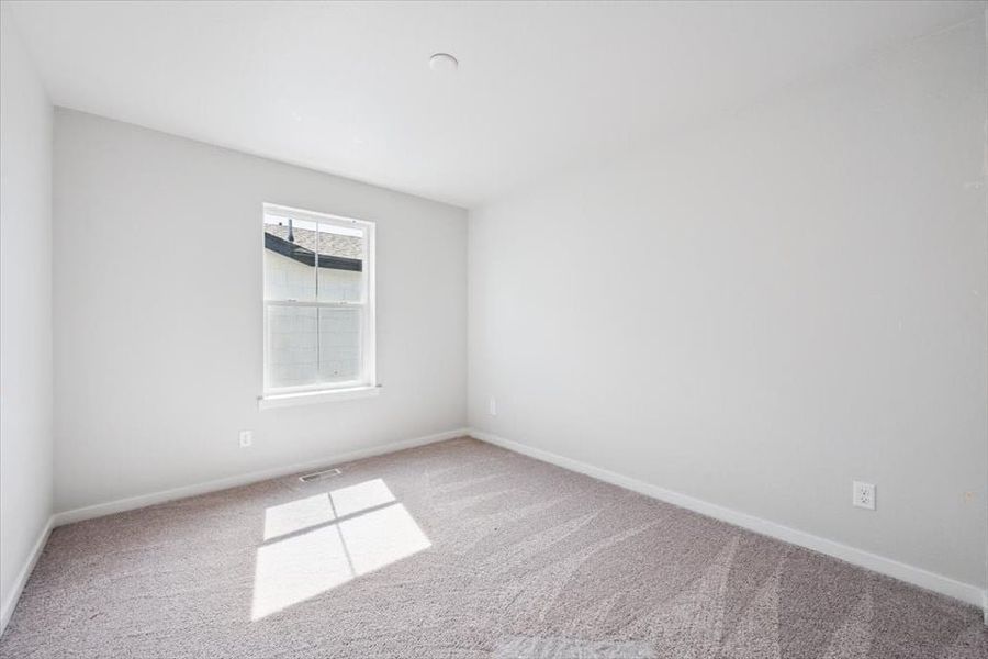 A room with a window and carpet.