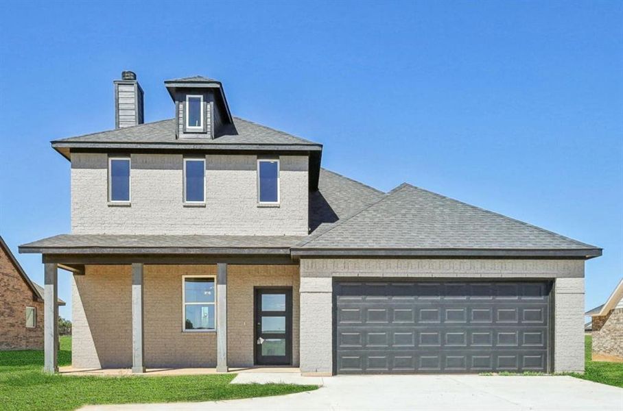 View of front of property featuring a chimney, brick siding, a garage, concrete driveway, and roof with shingles