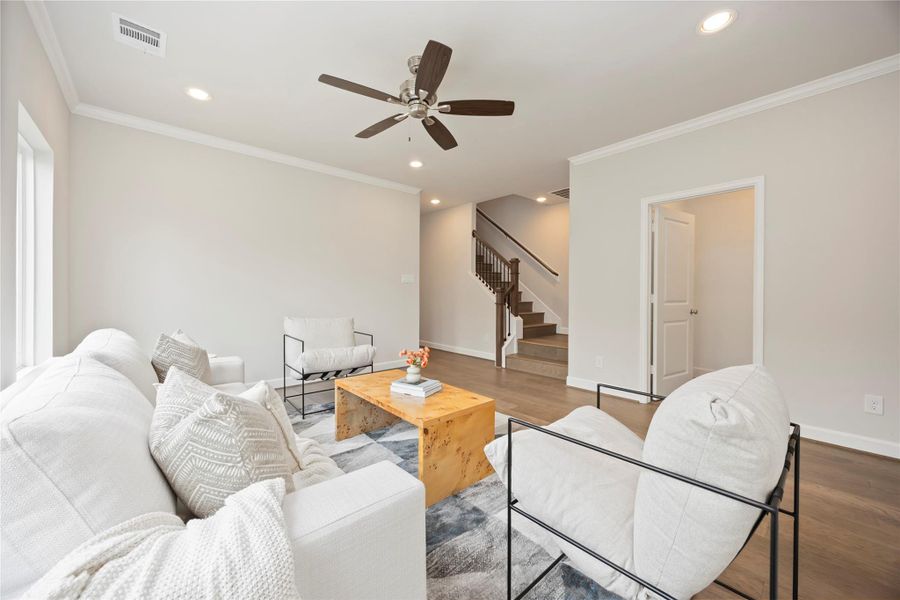 An alternate view of the game room shows a ceiling fan, access to the third level, and a journey down to the laundry room, defining multifunctional luxury.