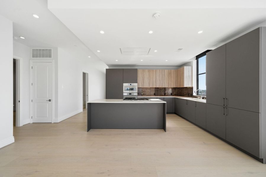 The large island serves as a central gathering place for family and friends, complementing the overall open-concept layout. The large island serves as a central gathering place for family and friends, complementing the overall open-concept layout.