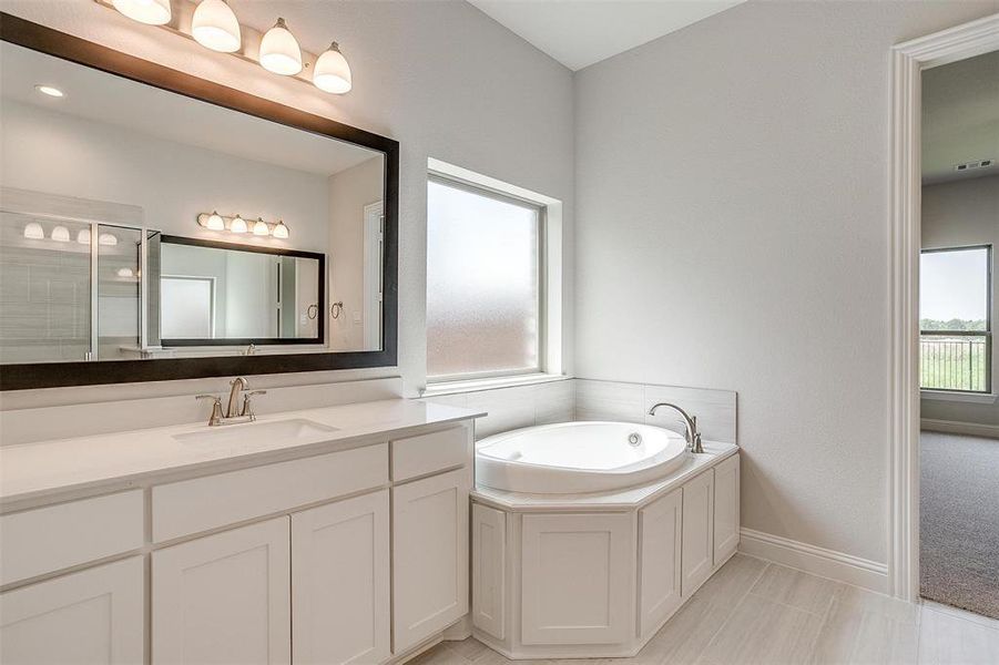 Bathroom featuring vanity, plus walk in shower, and tile patterned floors