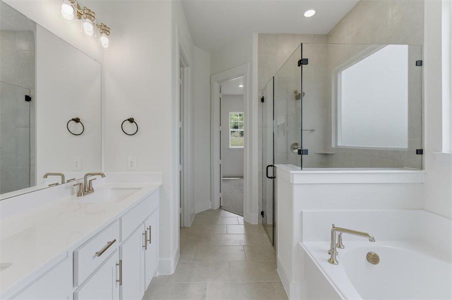 Contemporary bathroom featuring dual vanities with white cabinetry, light-toned countertops, and brushed nickel fixtures