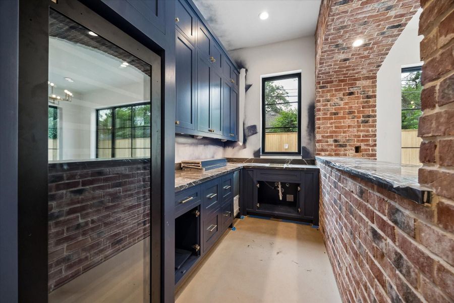 Perfect for entertaining this elegant bar features full-size paneled wine refrigerator, ice maker and sink. Pictured April 2026.