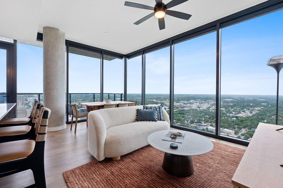 Representative Photo. Open Concept living room with 7.5" wide Bella Cera hardwood flooring, recessed lighting, ceiling fan, and a balcony off the living room with a North East view