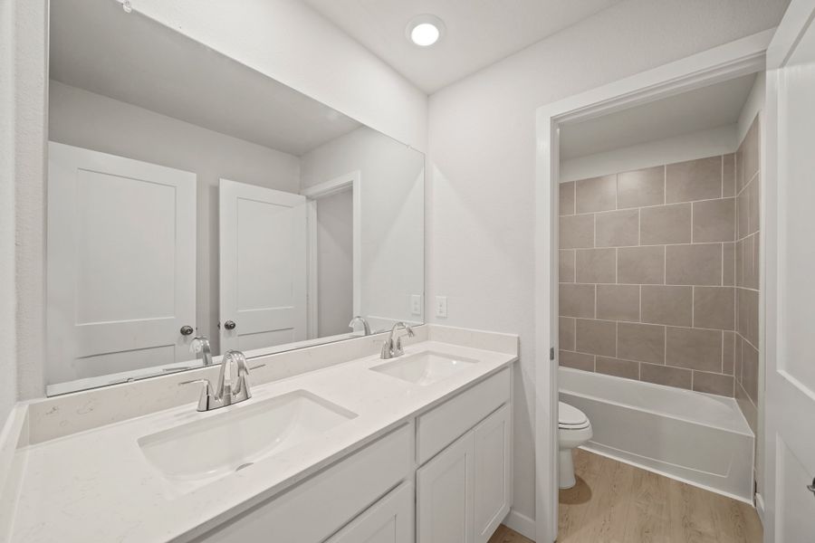 A bathroom with a tub sink and toilet.