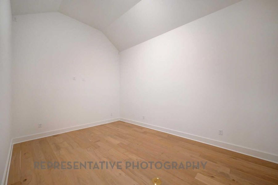 Spare room with lofted ceiling and light wood-style floors Spare room with lofted ceiling and light wood-style floors