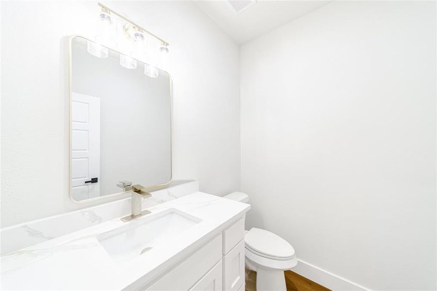Half bathroom featuring vanity and dark wood finished floors Half bathroom featuring vanity and dark wood finished floors