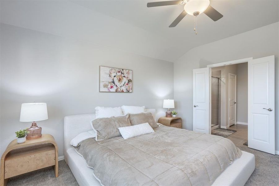 Bedroom featuring carpet flooring, vaulted ceiling, and ceiling fan Bedroom featuring carpet flooring, vaulted ceiling, and ceiling fan