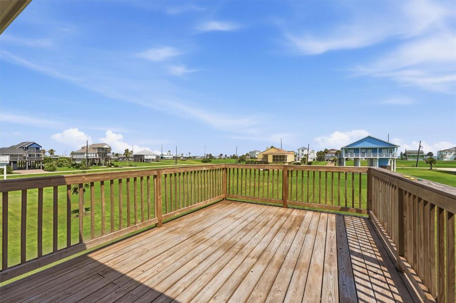 Spacious wooden deck offering panoramic views of a serene neighborhood with lush green lawns and charming homes. Spacious wooden deck offering panoramic views of a serene neighborhood with lush green lawns and charming homes.