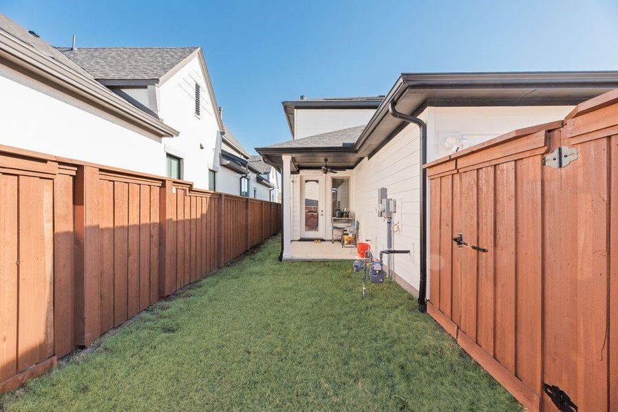 Fenced backyard featuring a patio area and ceiling fan