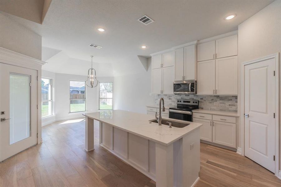 Kitchen featuring sink, white cabinets, light hardwood / wood-style floors, and appliances with stainless steel finishes