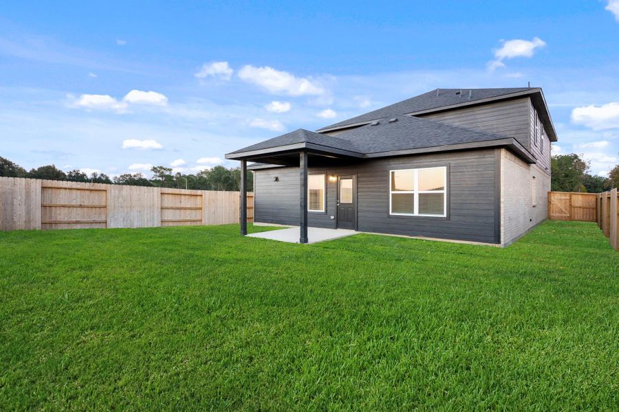 Enjoy a view of the spacious backyard complete with a covered patio and plenty of open green space, perfect for outdoor dining, playtime, or simply relaxing in the fresh air.
