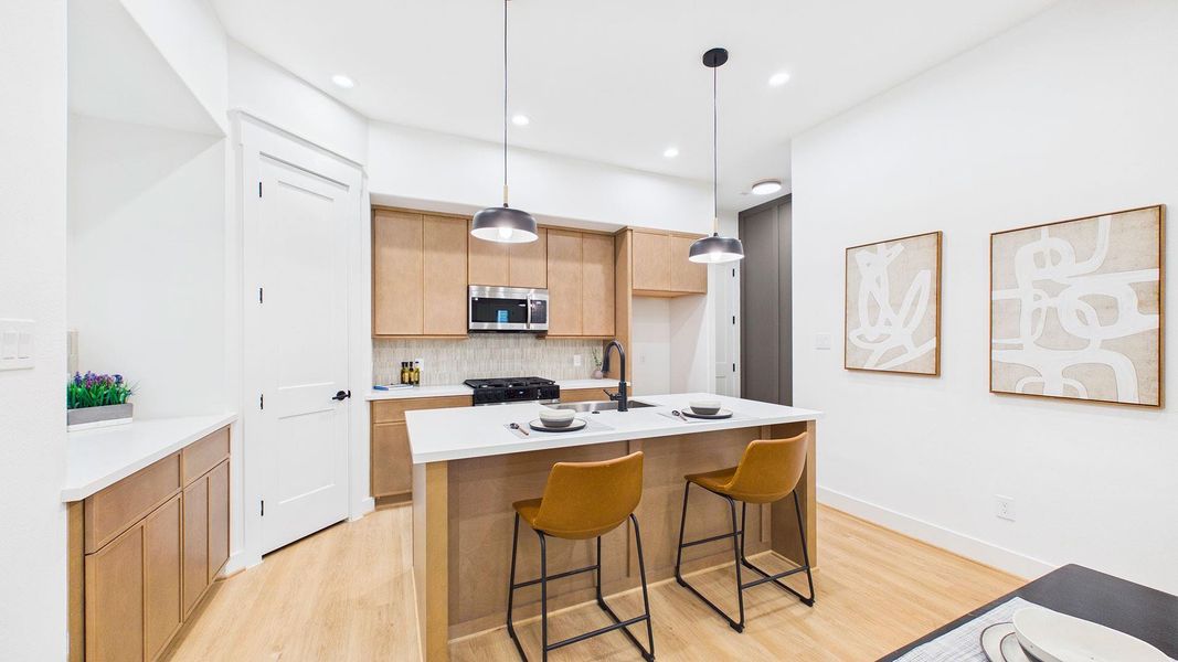 Chef's kitchen with quartz island and countertops, soft close cabinetry, and walk-in pantry.
