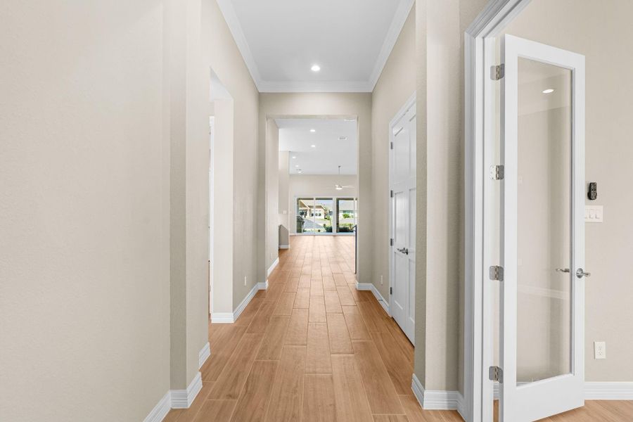 A bright and welcoming entry with double doors, soaring ceiling, and  beautiful wood-look floors leading into the main living spaces. Recessed lighting and clean lines create an open, airy feel throughout.