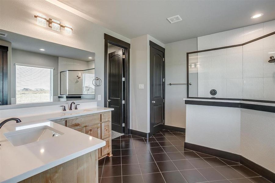 Bathroom with tile patterned flooring, vanity, and tiled shower