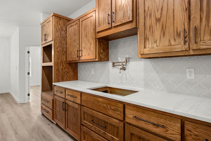 Elegant wooden cabinetry with white countertops, ready for a culinary upgrade. Elegant wooden cabinetry with white countertops, ready for a culinary upgrade.
