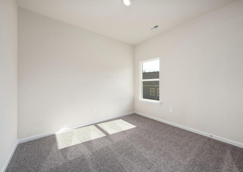 Each of the secondary bedrooms include tan carpets, closets, and bright windows