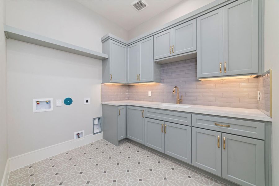 Large laundry room with extensive cabinetry and counter space. Access to the primary closet is an added bonus!