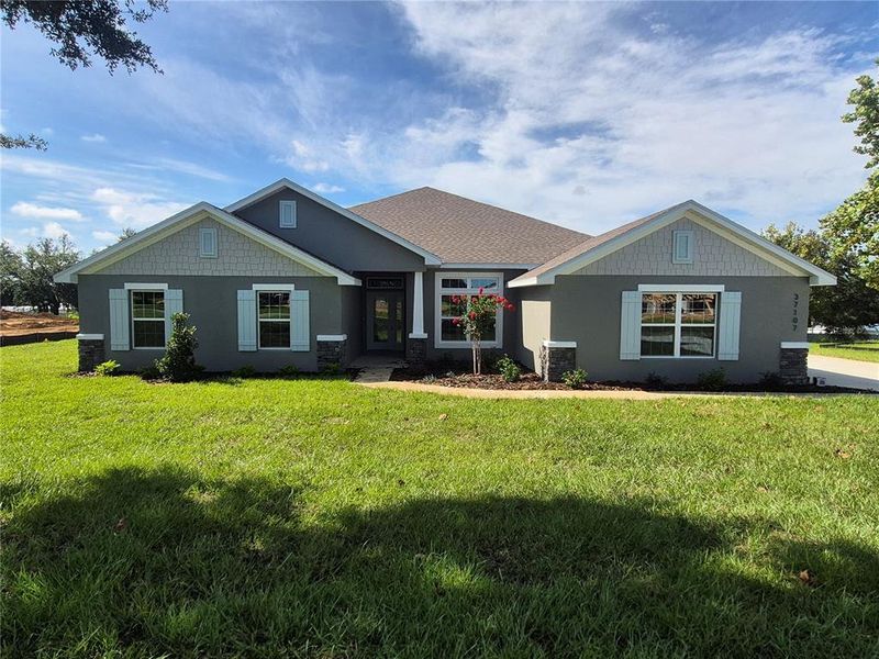 Front exterior of a new home in Hill Country Estates, Dade City, FL, highlighting curb appeal (Image 1). Front exterior of a new home in Hill Country Estates, Dade City, FL, highlighting curb appeal (Image 1).