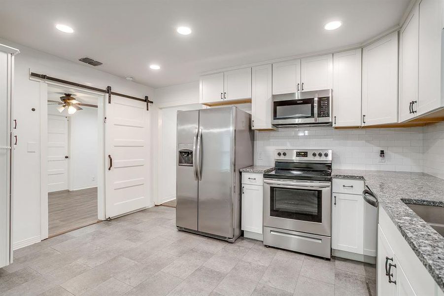 Kitchen with stainless steel appliances, backsplash, and recessed lighting