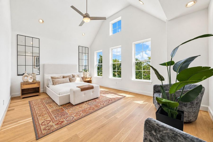 Bright, spacious primary suite features HIGH ceilings, abundant light, and real wood floors.