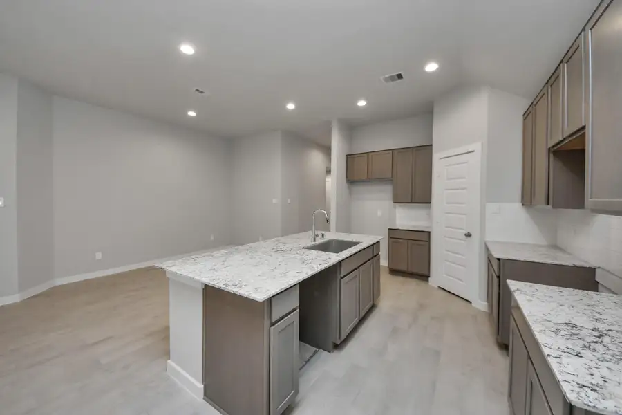 Discover another perspective of this stunning kitchen, generously appointedwith an abundance of counter space. Sample photo of completed home with similar floor plan. Actual colors and selections may vary.