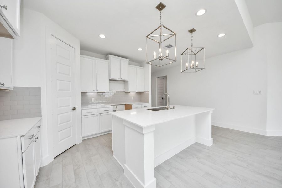 This kitchen is truly a chef's dream! This haven Boasts high ceilings, recessed & pendant lighting, stained wood cabinets, granite countertops, stainless steel appliances, a modern tile backsplash.  All of this overlooks your expansive family room, creating a perfect space for culinary delights and family gatherings.