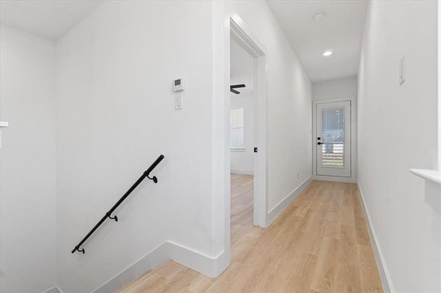 Hall featuring recessed lighting, baseboards, light wood finished floors, and an upstairs landing