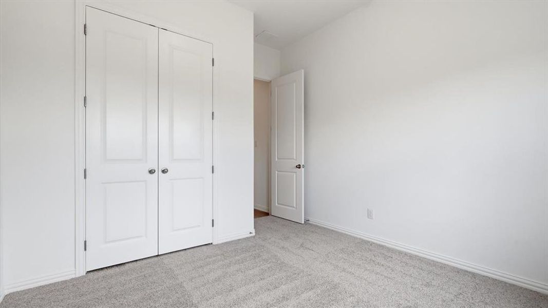 Bright room featuring light grey carpeting, white baseboards, and crisp white walls Bright room featuring light grey carpeting, white baseboards, and crisp white walls