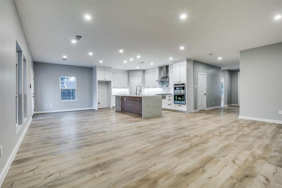 Unfurnished living room with light wood-type flooring and sink