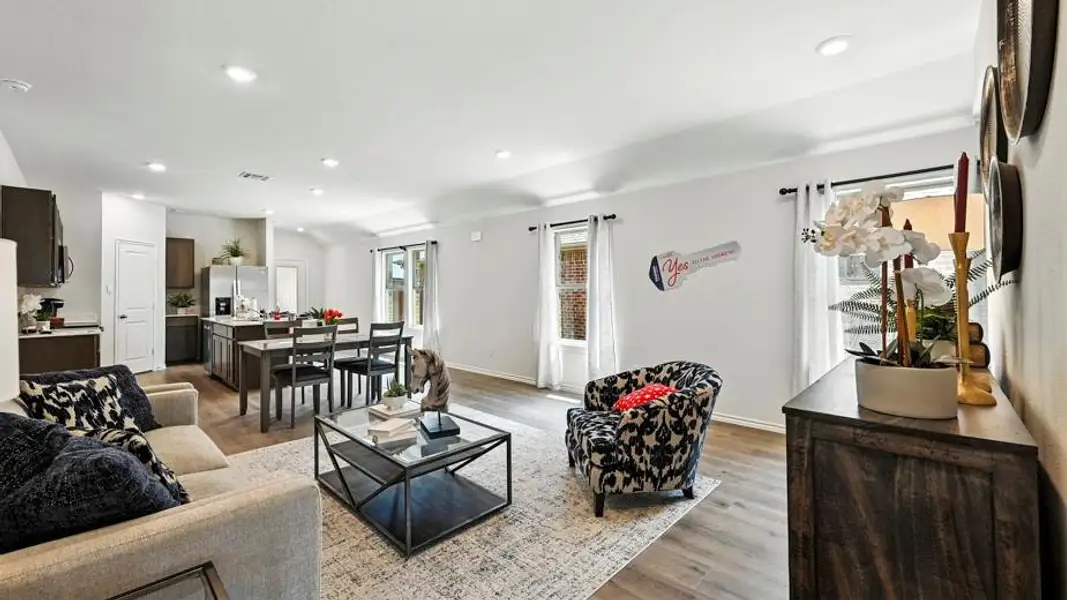 Open-concept living space featuring wood-finish flooring, recessed lighting, and white walls
