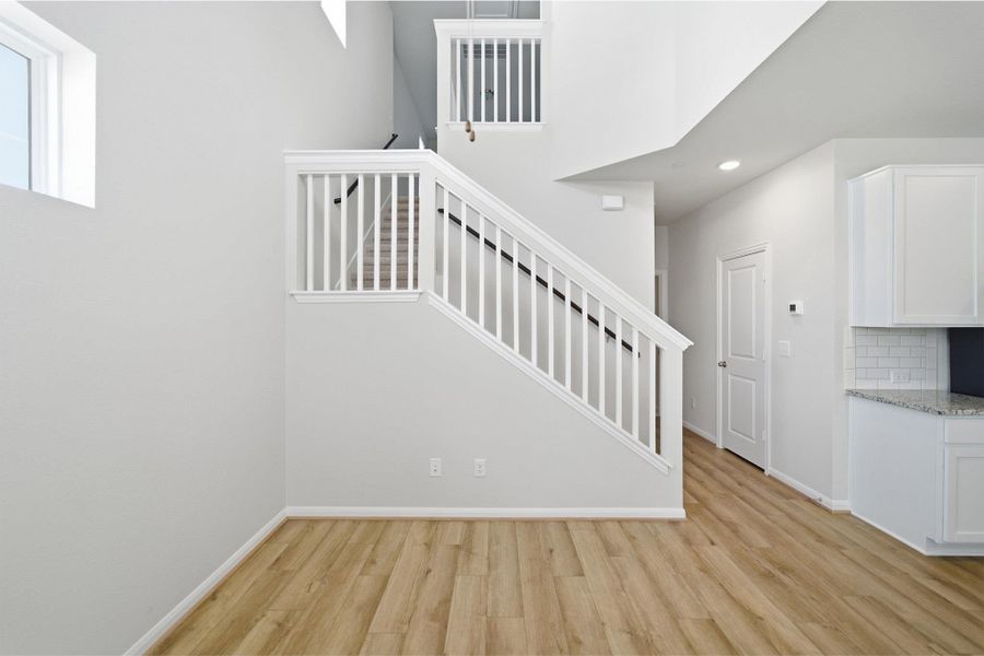 Stairway featuring wood finished floors and recessed lighting