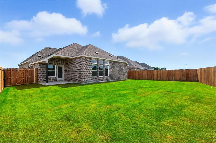 Back of property featuring a patio area, brick siding, a fenced backyard, and a shingled roof Back of property featuring a patio area, brick siding, a fenced backyard, and a shingled roof
