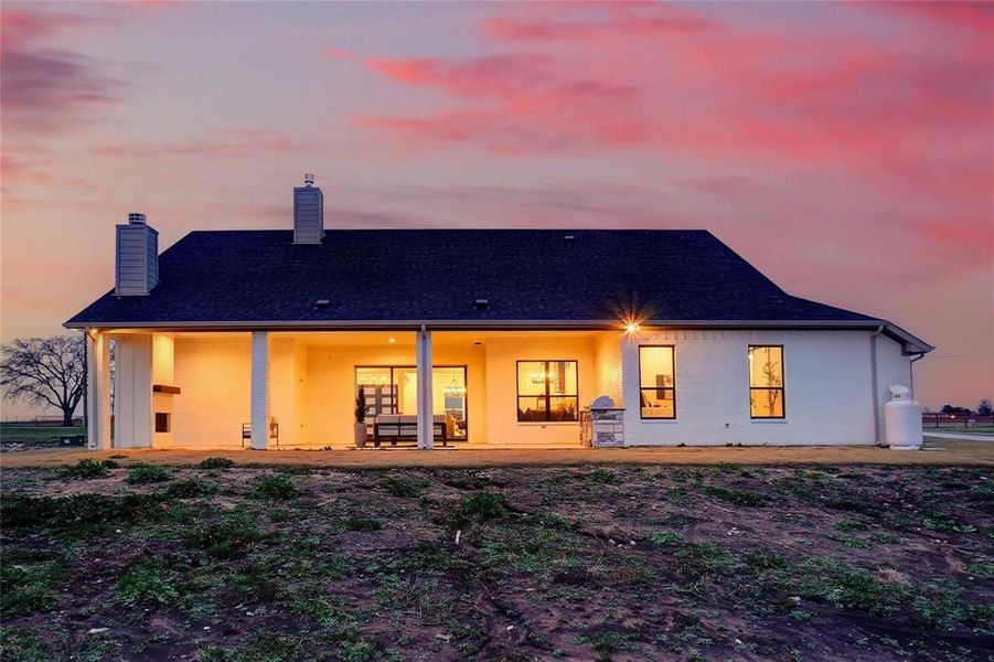 Back of house with a chimney, a patio, stucco siding, and a shingled roof