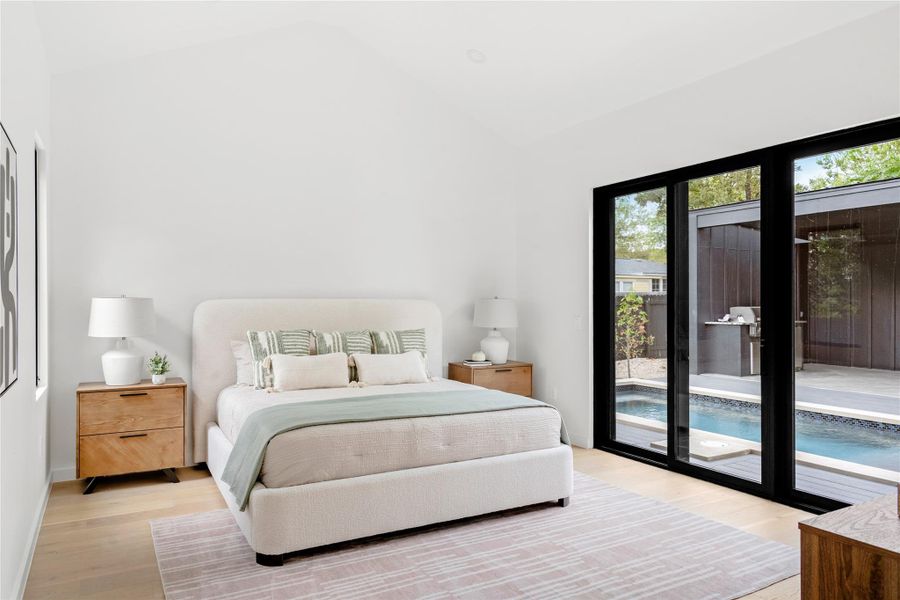 Bedroom with light wood-style flooring, access to outside, and high vaulted ceiling