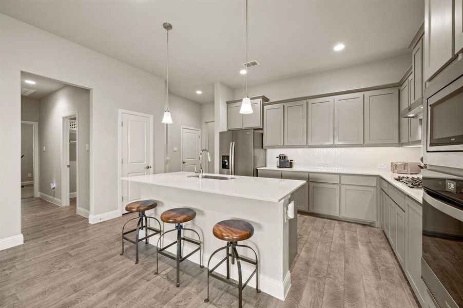 Wide view of the kitchen with oversized center island and pendant lights, perfect for entertaining or family gatherings.