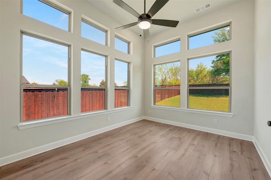 Unfurnished sunroom with wood finished floors and baseboards
