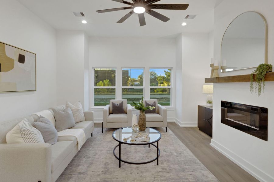 Inviting living room with large windows, a modern electric fireplace, and a wood mantel that adds warmth and character to the space. Inviting living room with large windows, a modern electric fireplace, and a wood mantel that adds warmth and character to the space.