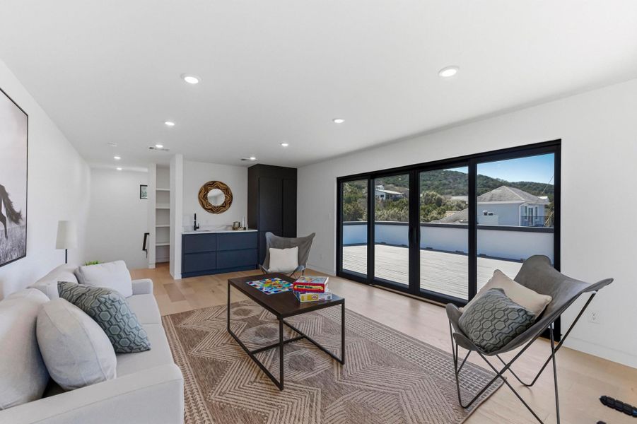 Living room with light wood finished floors and recessed lighting