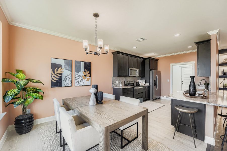 Dining room featuring crown molding, a chandelier, light wood finished floors, and recessed lighting