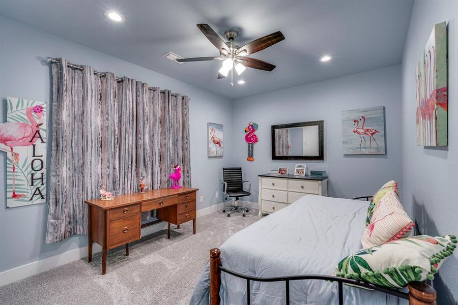 Carpeted bedroom featuring ceiling fan
