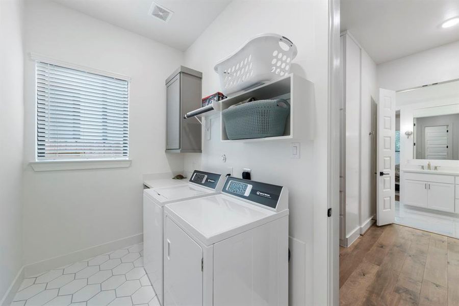 The primary closet conveniently connects to the utility room, which boasts a window and stylish geometric tile flooring, adding both functionality and charm to the space.