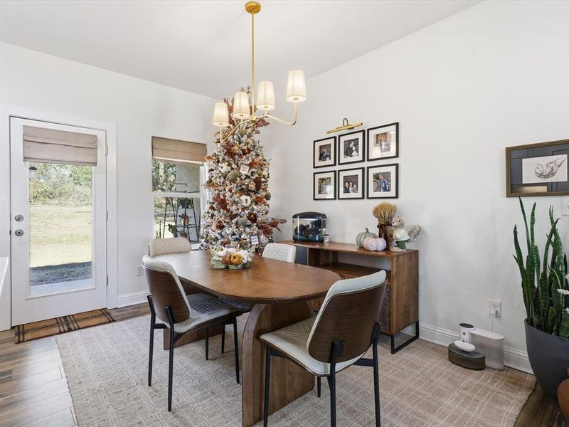 Dining space with wood finished floors and a chandelier