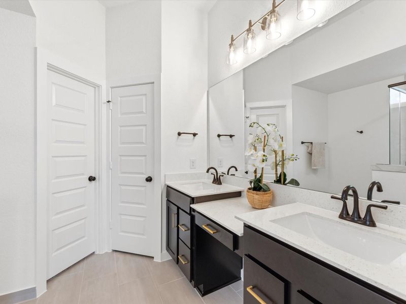Primary bath features separate sinks with a vanity between. Primary bath features separate sinks with a vanity between.