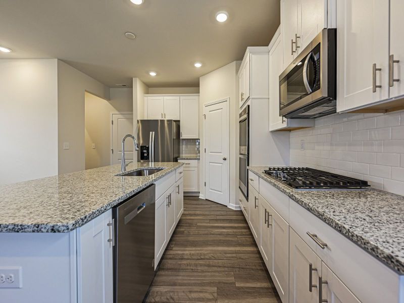 The well-appointed kitchen offers a walk-in pantry and large kitchen island.