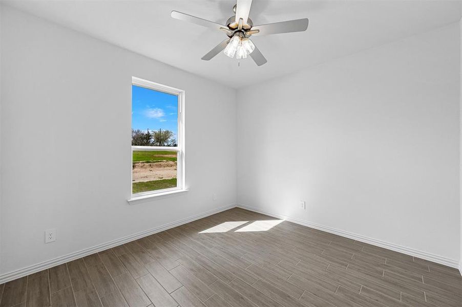 Empty room featuring hardwood / wood-style flooring and ceiling fan