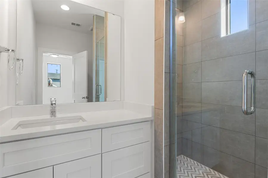 Bathroom featuring a shower stall and vanity