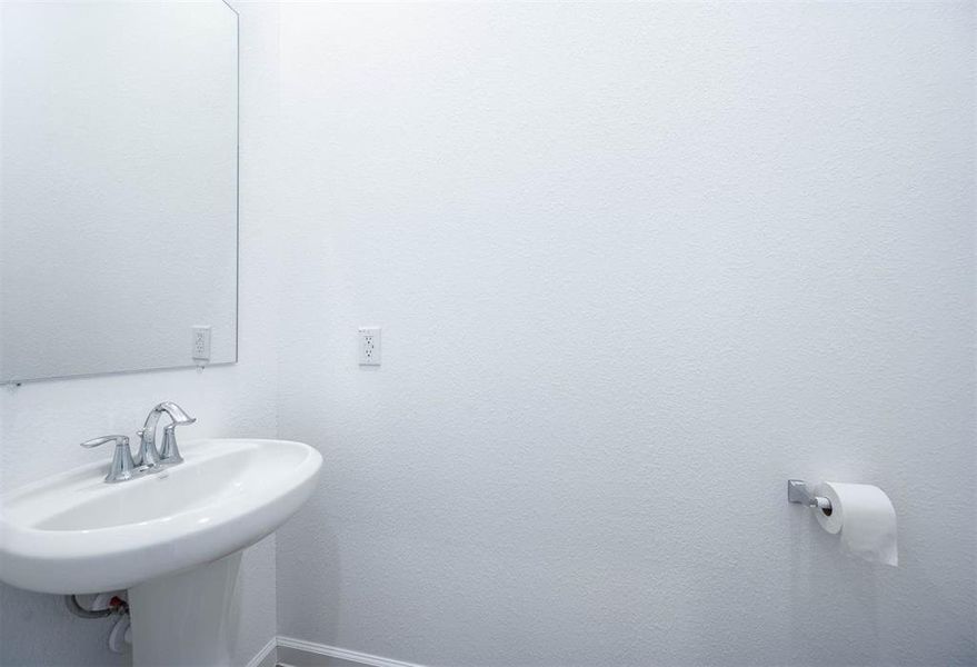 A sleek and simple half bathroom featuring modern fixtures, ideal for guests and everyday convenience.