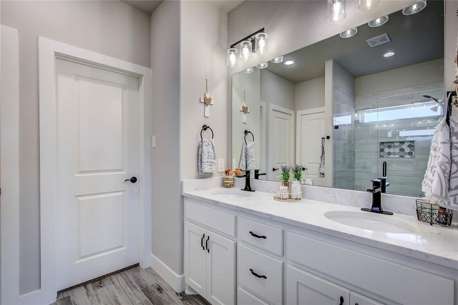 Bathroom with vanity, a shower with shower door, and hardwood / wood-style flooring