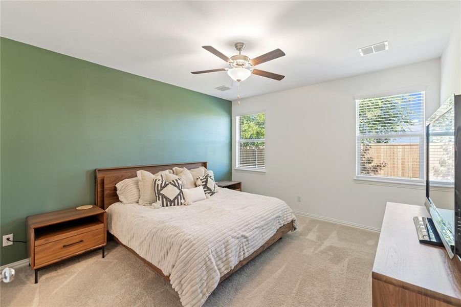 Bedroom with ceiling fan and light colored carpet